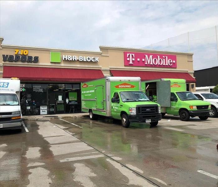 Two SERVPRO vans outside strip mall.