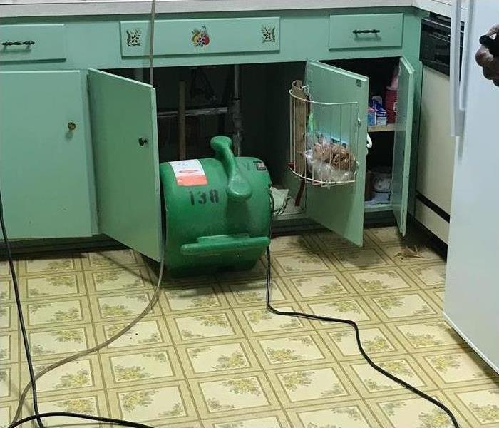 air mover placed in front of kitchen sink. Concept of water damage from 